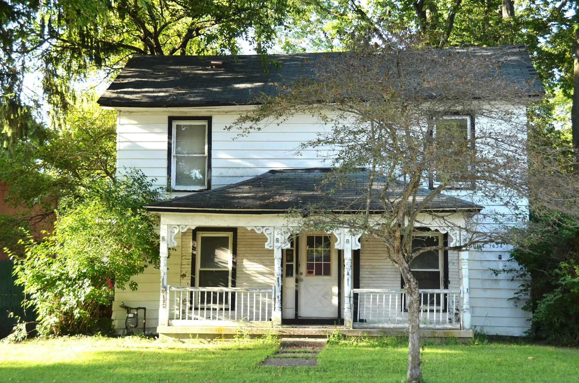 Older white farmhouse with a front porch